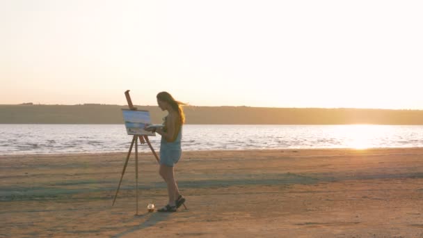 Female artist painting on beach — Stock Video