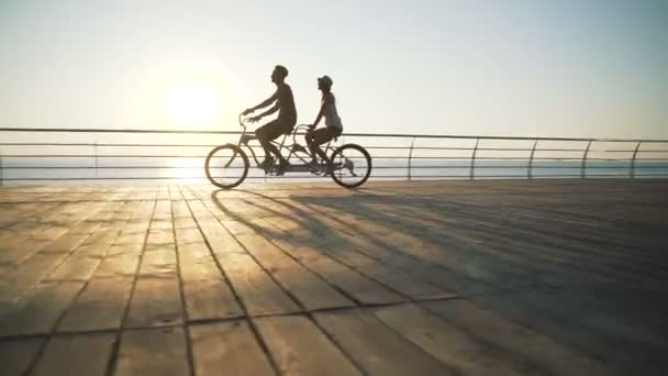 Jong koppel paardrijden tandem fiets — Stockvideo