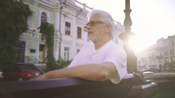 Starszy człowiek w parku na zachód słońca — Wideo stockowe