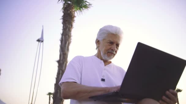 Senior man met laptop — Stockvideo