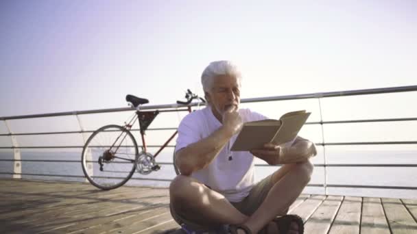 Homme âgé lisant le livre — Video