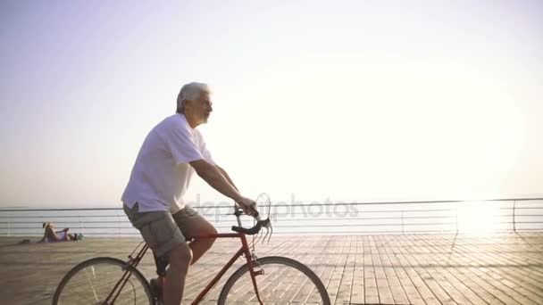 Homem sênior com bicicleta de engrenagem fixa — Vídeo de Stock