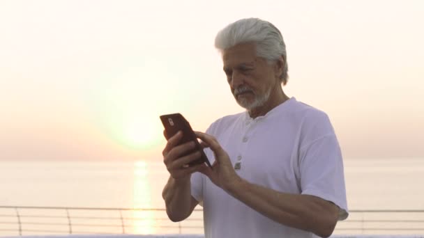 Senior man met mobiele — Stockvideo