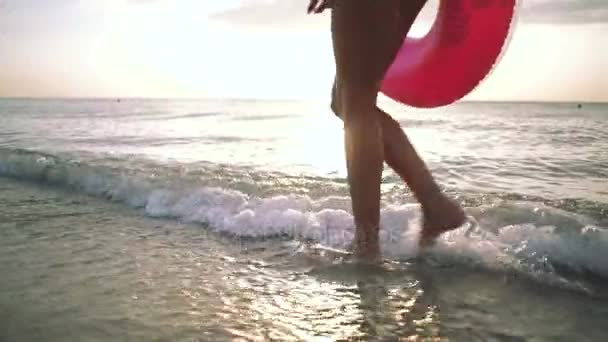 Frau läuft mit rosafarbenem Schwimmer — Stockvideo