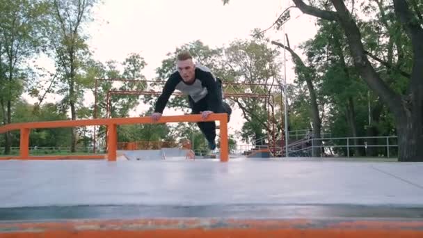 Чоловік стрибає в парку з пандусом — стокове відео