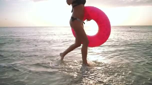 Frau läuft mit rosafarbenem Schwimmer — Stockvideo