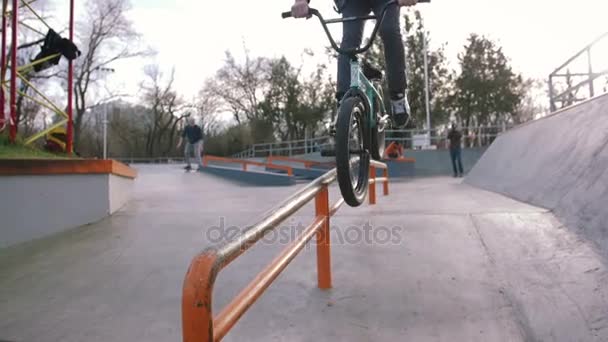 スケートパーク スローモーションでトリックを行う緑の Bmx の自転車にスポーティな若者 — ストック動画
