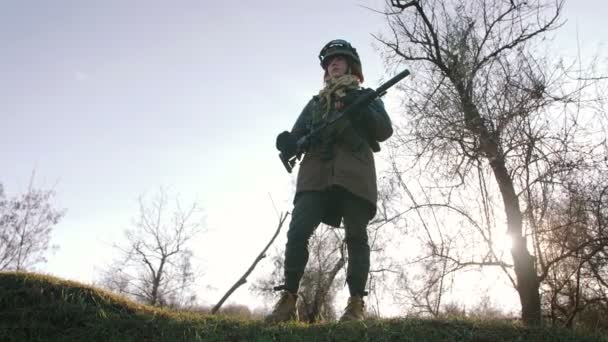 妇女在保护制服与枪在秋天森林戏剧 Strikeball 免版税图库视频片段