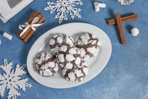 Вкусное мраморное печенье, усыпанное сахаром. Новогоднее пряничное печенье на голубом фоне с корицей, снежинками и зефиром. Домашняя праздничная выпечка на Новый год и Рождество . — стоковое фото