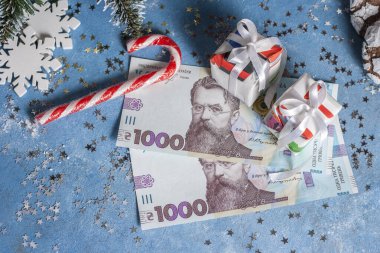 Yıldızlar, kar taneleri ve hediyelerle dolu mavi bir arka planda Ukrayna 1000 Hryvnia 'sı. Ukrayna 'da Noel ve Yeni Yıl hediyeleri alma kavramı