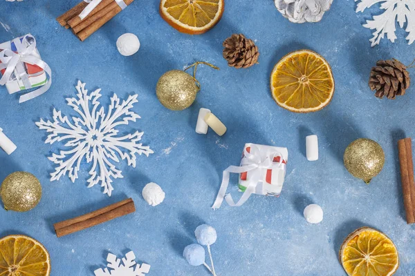 Рождественский и новогодний узор из снежинки, печенья, корицы, апельсина, шишек и зефира на синем фоне со звездами. Рождество, зима, новый год. Плоская кладка, вид сверху, копировальное пространство — стоковое фото