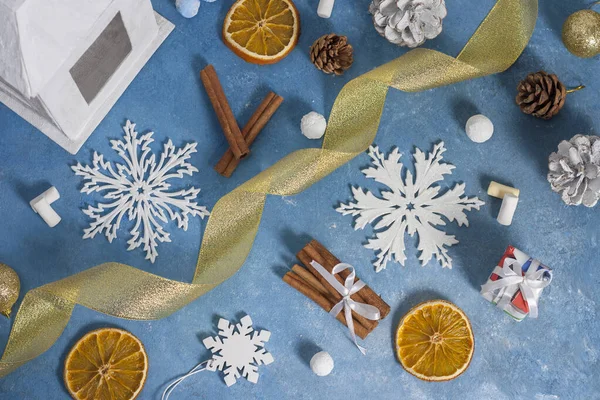 Рождественский и новогодний узор из снежинки, печенья, корицы, апельсина, шишек и зефира на синем фоне. Рождество, зима, новый год. Плоская кладка, вид сверху, копировальное пространство — стоковое фото