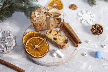 Geleneksel İtalyan bisküvisi ya da yuvarlak beyaz ahşap bir tahtanın üzerinde noel ağacının yanındaki ışık masasında tarçın, kurutulmuş portakal dilimleri ve lokum bulunan cantuccini kurabiyeleri. Noel pişirme konsepti