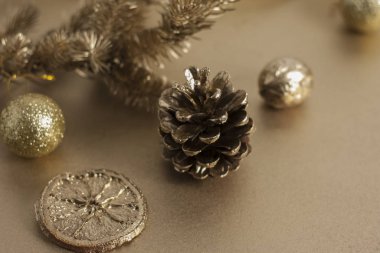 Noel veya Yeni Yıl kompozisyonu. Oyuncak, çam kozalağı ve kurutulmuş turuncu dilimli altın rengi bir Noel ağacı dalı. Tebrik kartı ya da davetiye için bayram ve kutlama kavramı