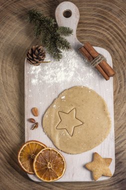 Noel ev yapımı pişirme arka planı: Tahta bir tahtanın üzerine zencefil hamuru, kurabiyeler, tarçın ve kuru portakal dilimleri. Üst görünüm, düz görünüm, kopyalama alanı.