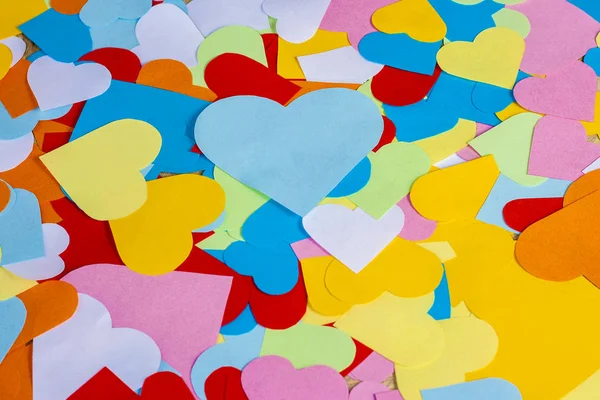 Jasné pozadí z mnohobarevných malých papírových srdcí: červená, modrá a žlutá. Skladba na Valentýna 14. února — Stock fotografie