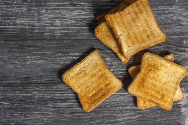 Tahta arka planda birkaç dilim kızarmış ekmek tostu.