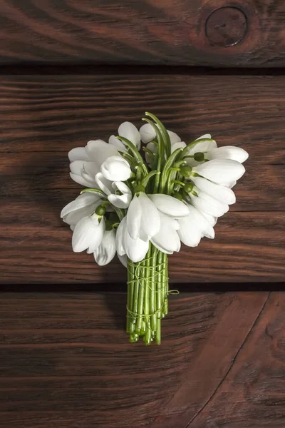 Красивые белые подснежники Galanthus nivalis на деревянном фоне с боке. Вид сверху, плоский — стоковое фото
