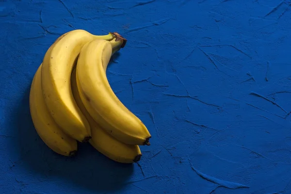 Banda Zralých Žlutých Banánů Modrém Pozadí Kopírovacím Prostorem — Stock fotografie