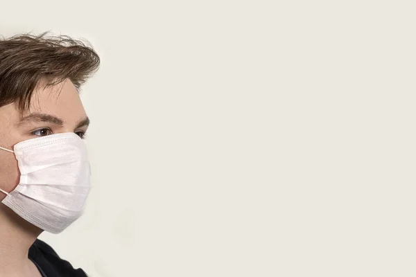 Corona Virus Jongeman Met Een Masker Een Grijze Achtergrond Bescherming — Stockfoto