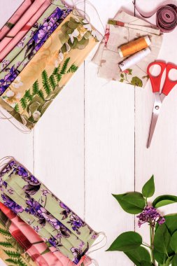 Koronavirüs el dikişlerinden koruyucu tıbbi maskeler üretiliyor. Hafif ahşap arka planda virüsün el yapımı tıbbi maskeleri..