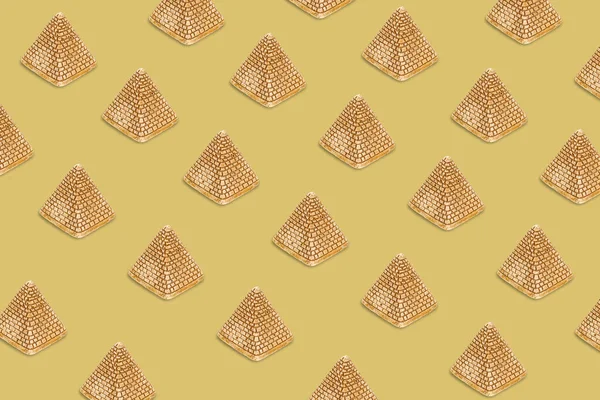 Patroon van gouden zand piramides op een beige achtergrond. Minimale toeristische achtergrond textuur. Creatieve indeling. Bovenaanzicht — Stockfoto