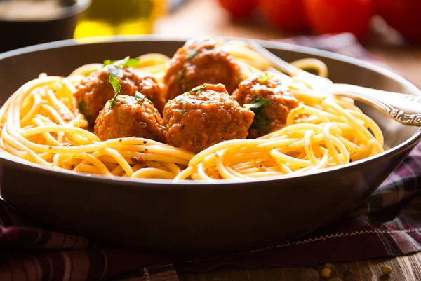 Pyszne spaghetti z klopsikami w sosie pomidorowym na ciemnym tle, kuchnia włoska — Zdjęcie stockowe