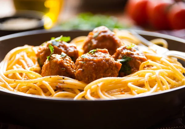 Espaguete delicioso com almôndegas em molho de tomate no fundo escuro, cozinha italiana — Fotografia de Stock