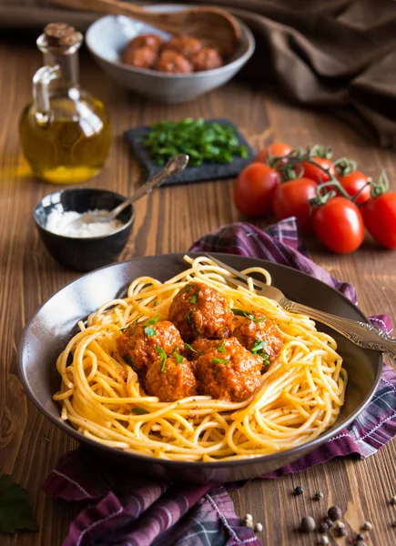 Delicious spaghetti with meatballs in tomato sauce on dark background, italian cuisine — Stock Photo, Image