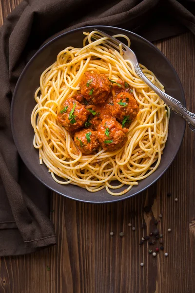 Pyszne spaghetti z klopsikami w sosie pomidorowym na ciemnym tle, kuchnia włoska — Zdjęcie stockowe