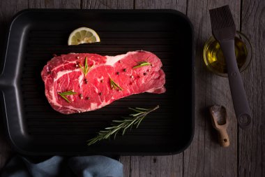 Çiğ et, biberiyeli pişmemiş biftek, limon ve siyah tavada baharat.
