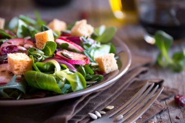 Turplu taze sebze salatası, roka, koyu ahşap üzerine kızarmış ekmek.