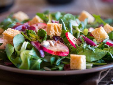 Turplu taze sebze salatası, roka, balzamik sirke ve koyu ahşap üzerine kızarmış ekmek.