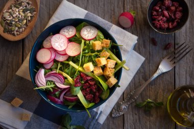 Turplu taze sebze salatası, roka, koyu ahşap üzerine kızarmış ekmek.