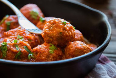 Domates soslu ev yapımı köfteler ve tavada maydanoz.