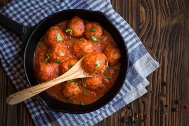 Domates soslu ev yapımı köfteler ve tavada maydanoz.