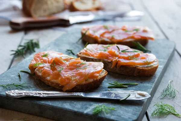 Sandwithes con salmón ahumado y queso cremoso sobre pan — Foto de Stock