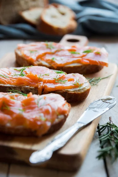 Sandwithes con salmón ahumado y queso cremoso sobre pan — Foto de Stock