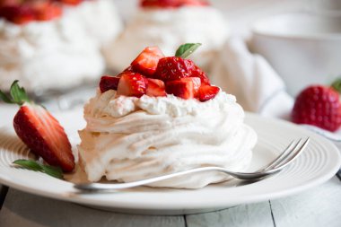 Kremalı ve taze çilekli lezzetli Pavlova keki.
