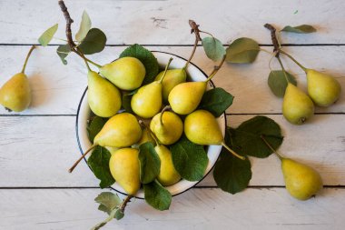 Beyaz ahşap yapraklı taze organik armut meyveleri.