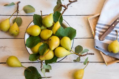 Beyaz ahşap yapraklı taze organik armut meyveleri.