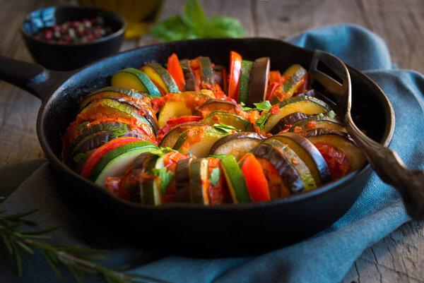 Homemade ratatouille made with sliced vegetables: zucchini, tomatoes and eggplant.