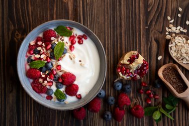 Taze meyve, nane ve mısır gevrekli yoğurt, sağlıklı bir kahvaltı.