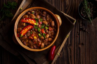 Siyah arka planda acı biberli soğuk fasulyeler.