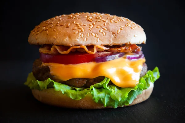 Hamburger Sýrem Slaninou Rajčaty Salátem Tmavém Dřevěném Pozadí — Stock fotografie