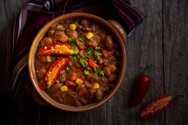 Siyah arka planda acı biberli soğuk fasulyeler.