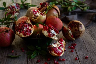 Koyu arkaplanda yaprakları olan taze organik nar.