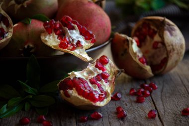 Koyu arkaplanda yaprakları olan taze organik nar.