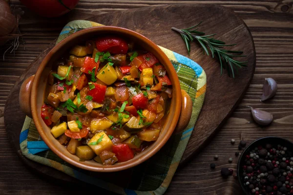 Chopped cooked vegetables on dark wood. ratatouille with zucchini, bell pepper and eggplant