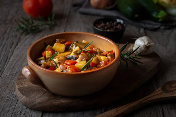 Chopped cooked vegetables on dark wood. ratatouille with zucchini, bell pepper and eggplant